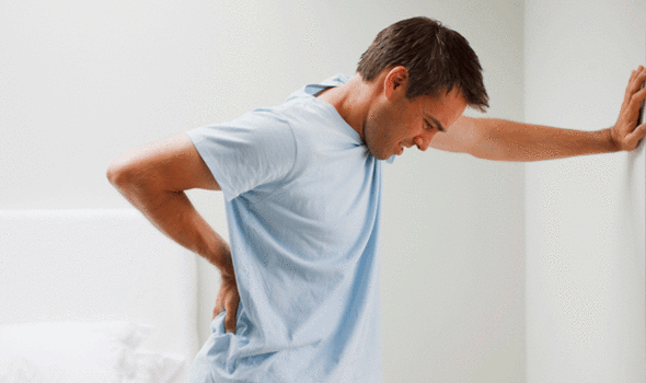 Man holding his low back because of back pain