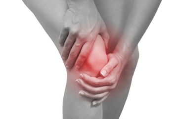 Person holding their knee because of pain