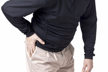 Photograph of of man holding hip because of hip pain